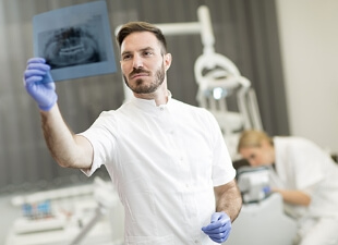 strahlenschutz360grad-small-dentist-analyzing-x-ray-of-teeth